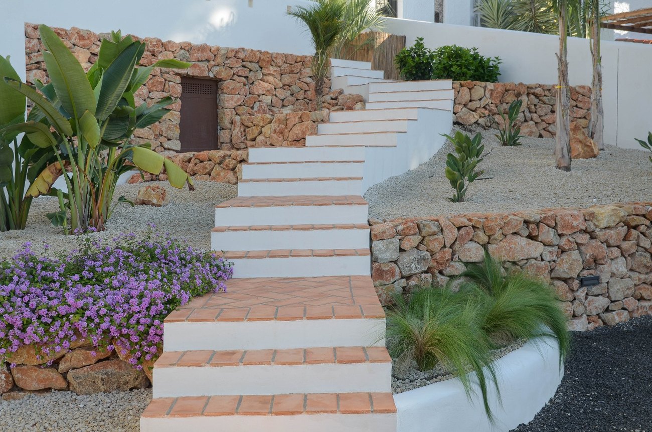 Casa Eucaliptus — escalera de baldosa por el jardín entre muros de piedra natural