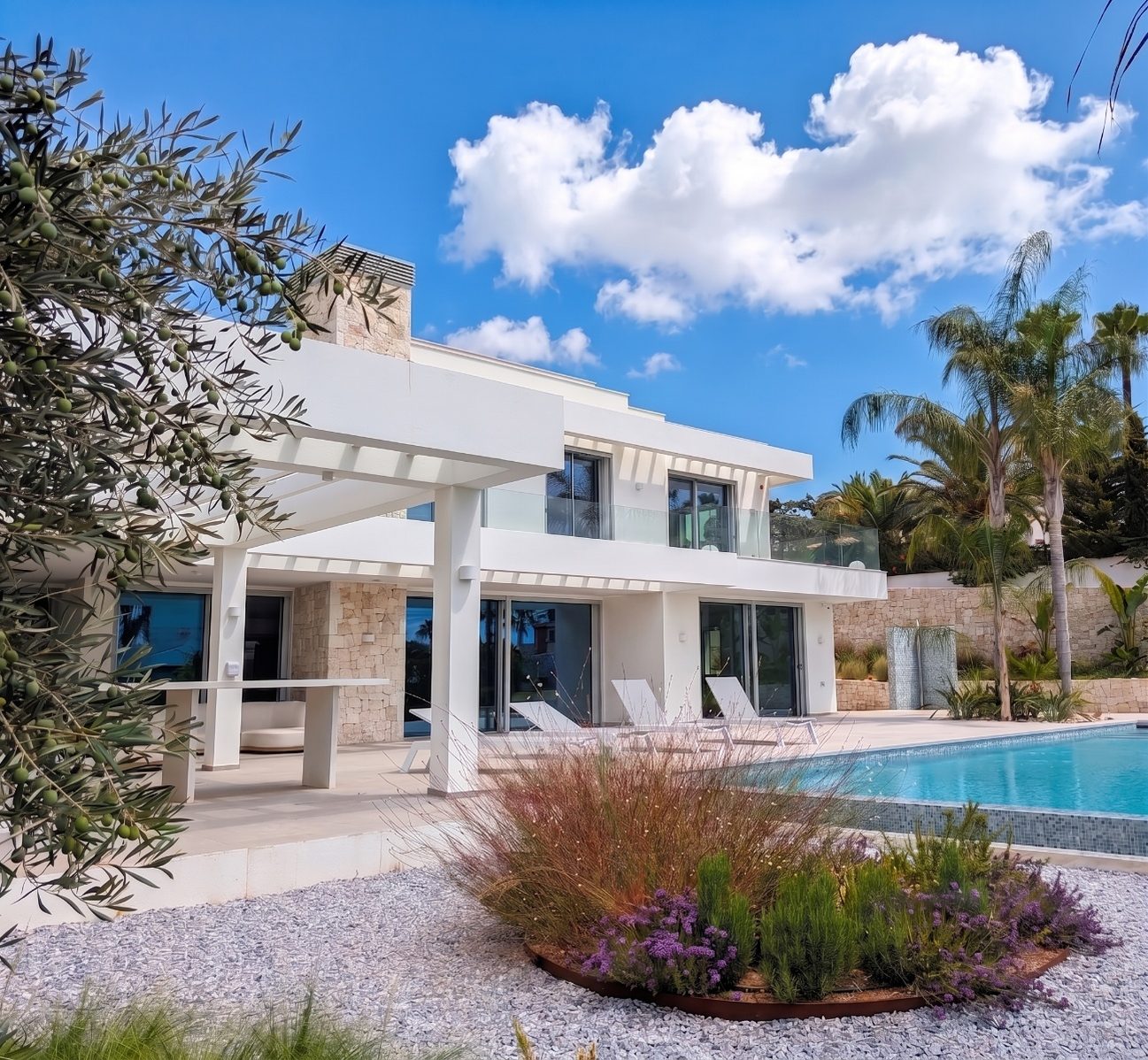 Villa Mar de Japón — lado del jardín con olivo, macizo de lavanda y la terraza cubierta bajo la pérgola