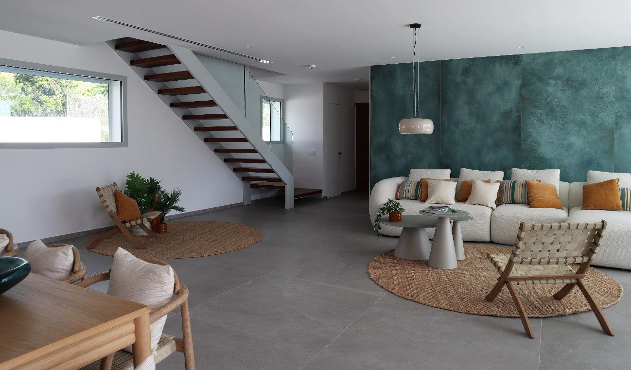Villa Mar de Japón — salón con escalera abierta y la zona de estar junto a la pared verde