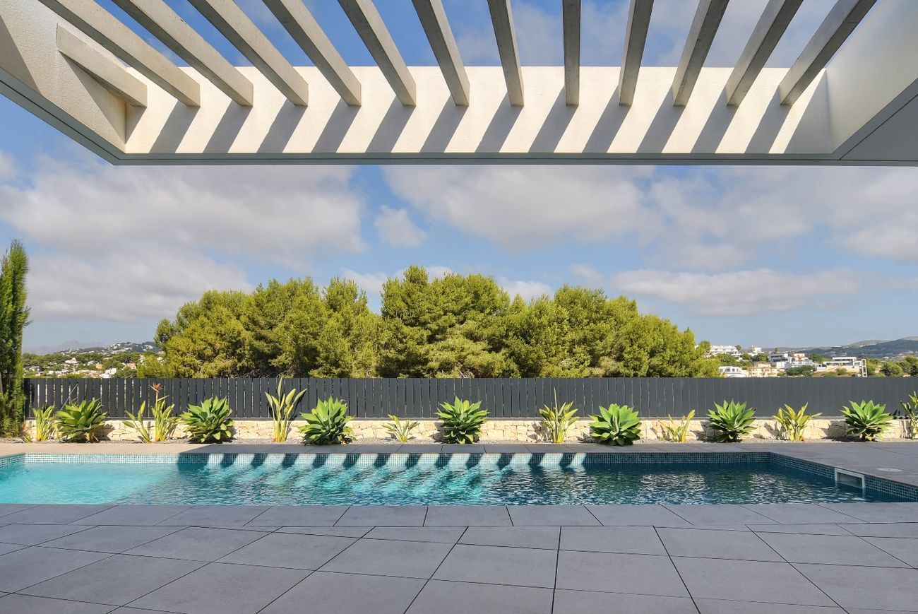 Casa Pintor Gris — vista desde bajo la pérgola hacia la piscina