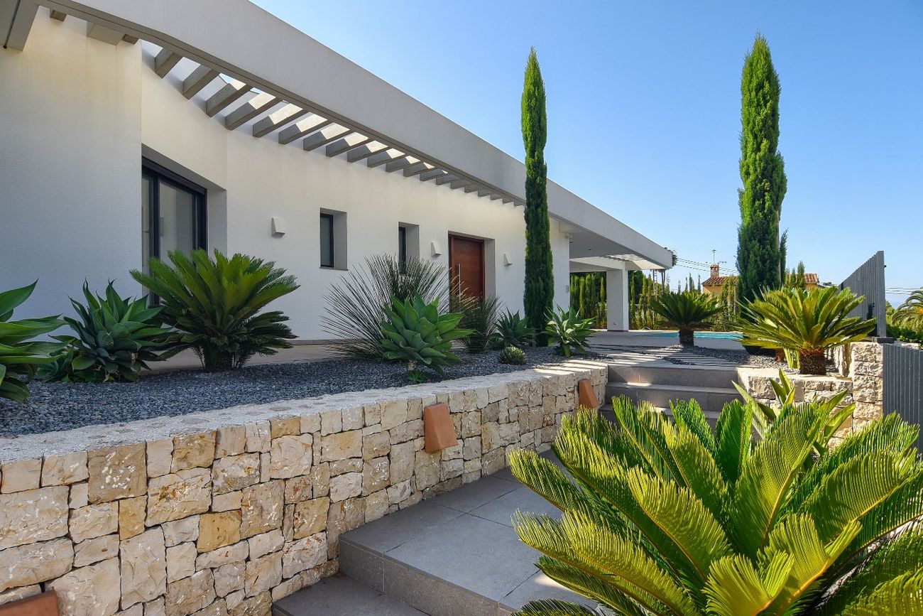 Casa Pintor Gris — fachada lateral con jardín